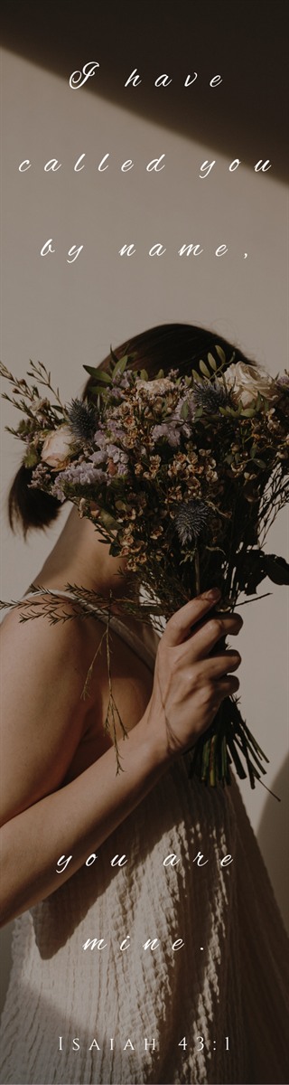 Bookmark reading I have called you by name, you are mine, in script over a woman holding a bunch of dried flowers in front of her face in low sunlight